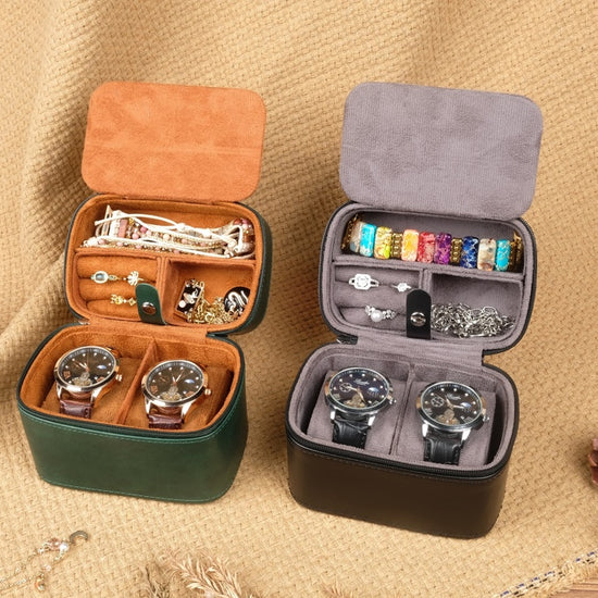 Two jewelry cases, one open with watches and accessories, the other closed, on a textured surface.