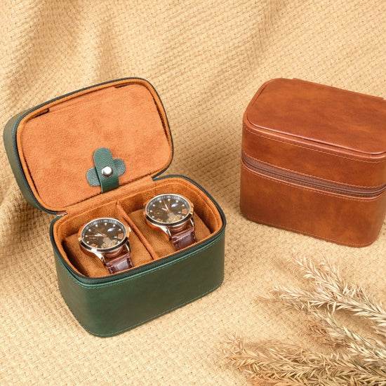 Two leather jewelry boxes, one open with watches inside, on a textured beige surface.